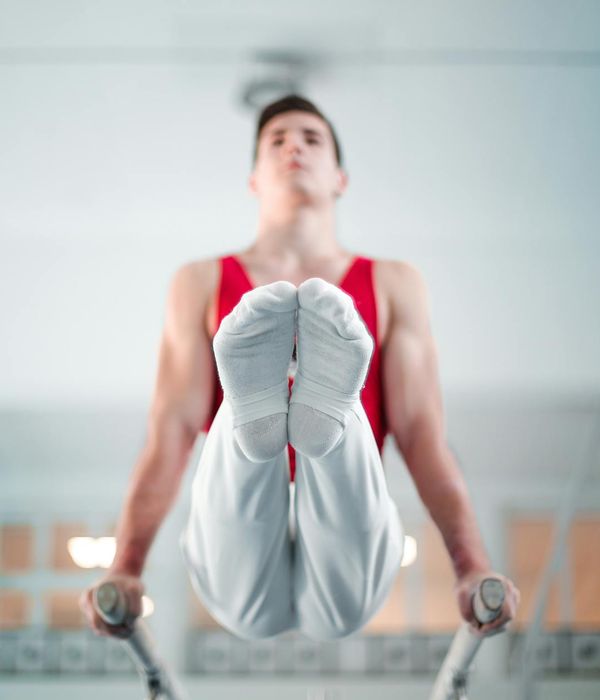 Man performing a controlled strength exercise in a minimalist dark gym.